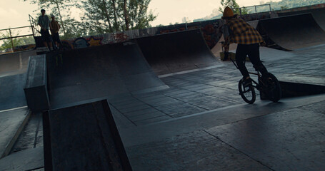 Millennial man performing extreme tricks on bmx bike at urban space. 