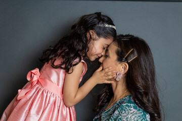 affectionate little girl touching her mom's face. hispanic family