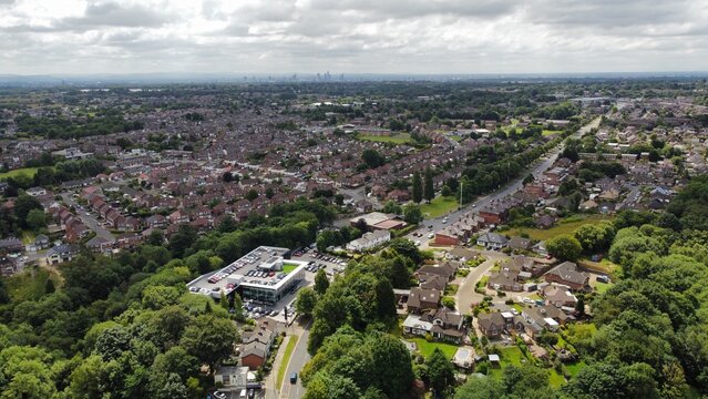 Aerial view looking down onto buildings and roads with views towards Manchester City centre in the background. Taken in Bury Lancashire England. 