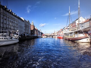 Beautiful shot of Nyhavn canal with boats between buildings in Copenhagen, Denmark