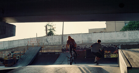 Active guys having fun at skate park. Sporty people riding together at skatepark