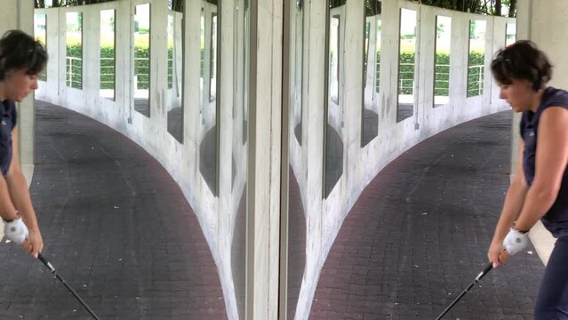 Double Golfer Practice Golf Swing in Driving Range with Mirror Image in Switzerland.