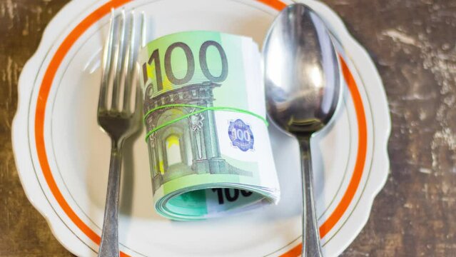 Money bills on a plate on a brown table. Increase in food prices due to the war in Ukraine