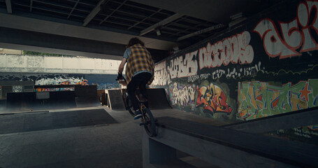 Naklejka na ściany i meble Extreme biker racing bmx bicycle in ramp at skatepark for active sport leisure. 