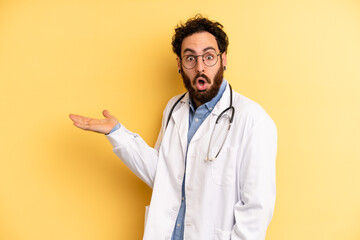 young man looking surprised and shocked, with jaw dropped holding an object. medicine student