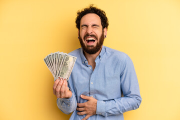 young man laughing out loud at some hilarious joke. dollar banknotes concept