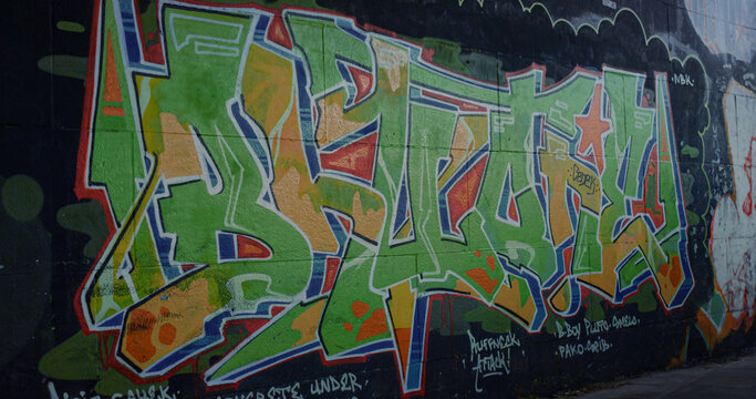Colorful graffiti on wall at skate park. Closeup street art drawing aerosol