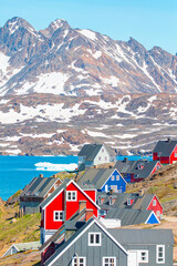 Night time in the northern hemisphere concept - Picturesque village on coast of Greenland - Colorful houses in Tasiilaq, East Greenland