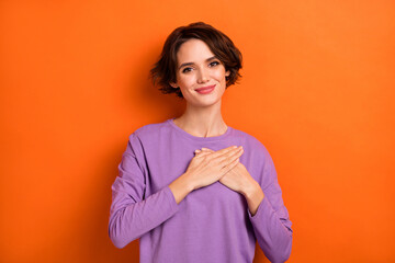Photo of gorgeous candid person arms palms touch heart look camera isolated on orange color background