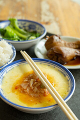 angle view fast food of two chicken thighs and steamed eggs and vegetable and bowl of rice vertical composition