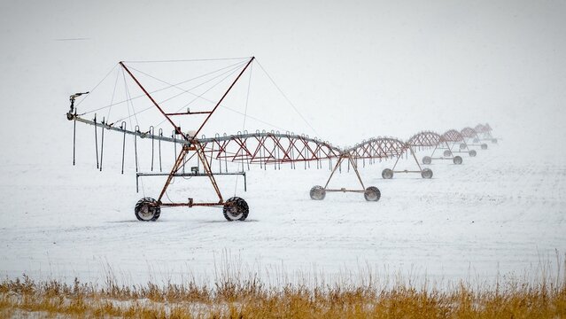 Center pivot irrigation system on the field covered by snow. Montana.