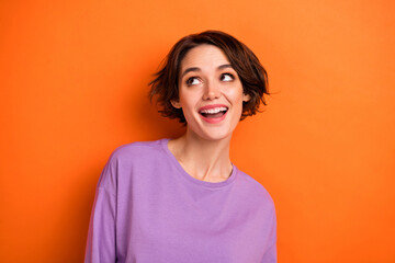 Photo of dreamy funny young lady wear violet sweatshirt looking up empty space isolated orange color background