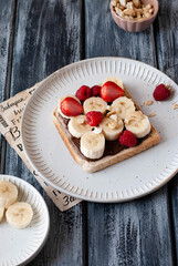 Breakfast toast with nut nougat cream, bananas and berries