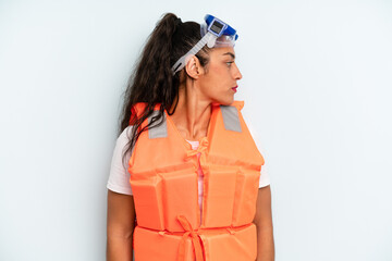 hispanic woman on profile view thinking, imagining or daydreaming. life jacket and summer concept