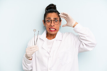 hispanic woman feeling stressed, anxious or scared, with hands on head. dentist concept