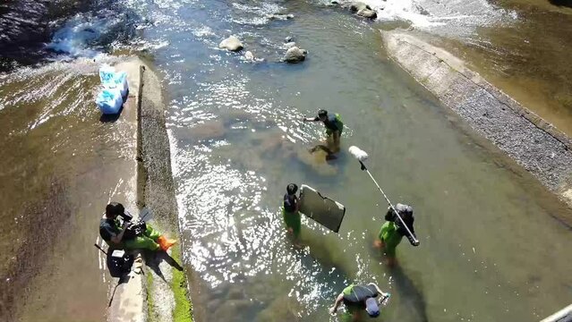 Beautiful high angle HD footage of people shooting a movie in the river in Asia