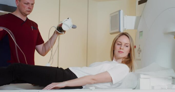 The doctor preparing young patient for an MRI scan in a modern clinic