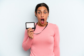 hispanic woman looking very shocked or surprised. vip pass card