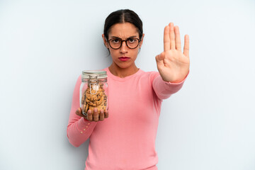 hispanic woman looking serious showing open palm making stop gesture. home made cookies concept - obrazy, fototapety, plakaty