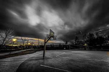 Fototapeten Breathtaking view of a basketball and volleyball courts against dark cloudy sky background © Gude Smokiedoc Tokerud/Wirestock Creators