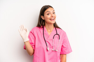pretty woman smiling happily, waving hand, welcoming and greeting you. nurse concept © kues1