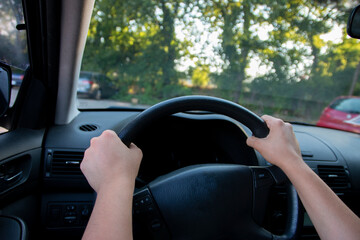Happy teen girl sitting on driver seat in new car joyful smiling hold hands on wheel. Successful...