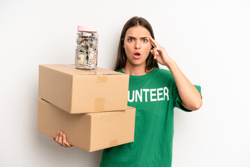pretty woman looking surprised, realizing a new thought, idea or concept. volunteer and donation...