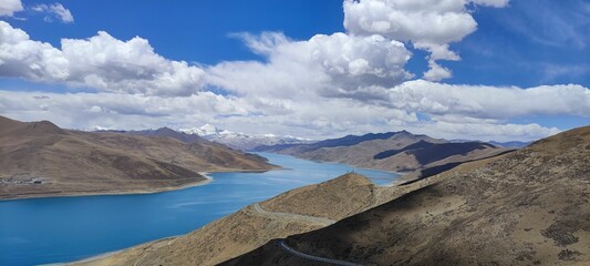 Panoramic view of blue Yamdrok  lake with mountains under blue sky and white clouds. Tibet. - Powered by Adobe