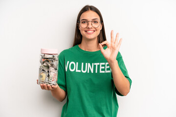 pretty woman feeling happy, showing approval with okay gesture. volunteer and donation concept