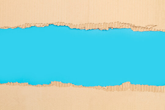 Textura de papel rasgado, cart&oacute;n corrugado sobre un fondo celeste. Vista superior y de cerca. Copy space