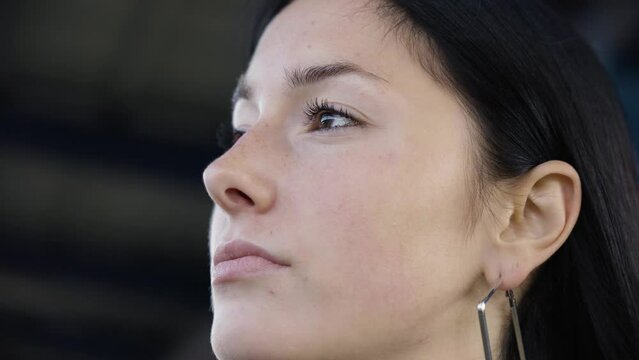 A young beautiful Caucasian woman looks around - closeup from below