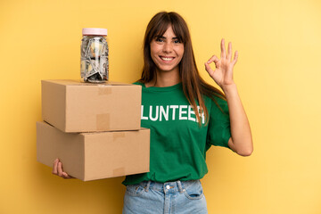 pretty woman feeling happy, showing approval with okay gesture. volunteer and donation concept