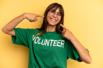 pretty woman smiling confidently pointing to own broad smile. volunteer and donation concept