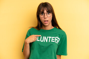 pretty woman looking shocked and surprised with mouth wide open, pointing to self. volunteer and...