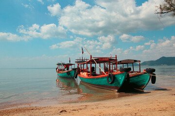 Naklejka na ściany i meble Khmer fishing boats moored at the shore of Koh Tonsay Island or Rabbit Island, popular summer destination in Cambodia
