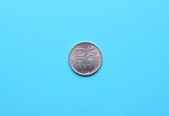 Russian national coin of denomination of one ruble close-up on a blue background.