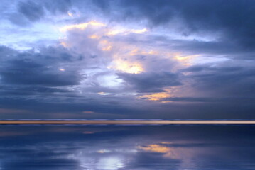 Fototapeta na wymiar dramatic blue lilac sunshine cloudy sky sunset on sea before storm nature landscape