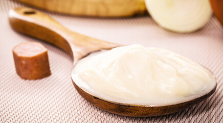 spoon of pork fat, lard used as a culinary ingredient in Brazil, pork meat in the background