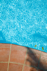 Fototapeta na wymiar Side of pool and transparent turquoise, clear water, no one. Summer background