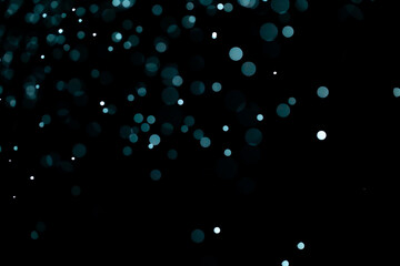 Glowing blue highlights. Wallpaper pattern. Blue sparkling spots. Dust or fog on a black background.