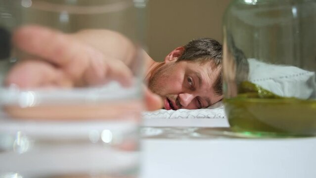 A drunk man with an alcohol addiction takes a a glass of alcohol