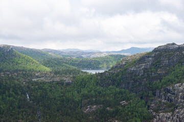 Fototapeta na wymiar Breathtaking Norwegian nature of trees and waterfalls between mountains