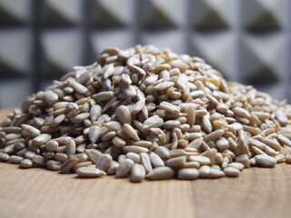 A pile of peeled sunflower seeds on a wooden surface, macro shot.