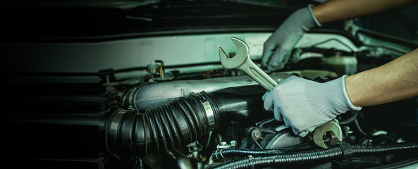 Fototapeta na wymiar Mechanic works on the engine of the car e in the garage,car repair service.
