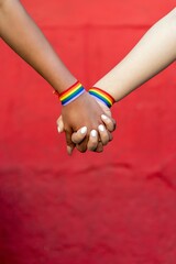 lesbia couple holding hands with gay pride bracelet