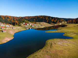 Fototapeta na wymiar Aerial beautiful view of Sultanpinar Plateau in Bolu Turkey in autumn in which mountains, forest, houses and lake are visible with blue sky