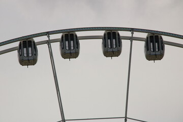 Gondeln von einem Riesenrad vor einem wolkigen gewittrigen Himmel