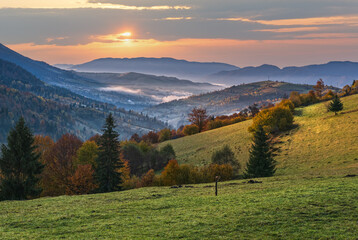 Foggy early morning autumn mountains scene. Peaceful picturesque traveling, seasonal, nature and countryside beauty concept scene. Carpathian Mountains, Ukraine.