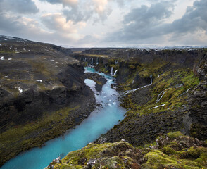 Autumn snowfall on picturesque waterfall Sigoldugljufur  view. Season changing in southern Highlands of Iceland.