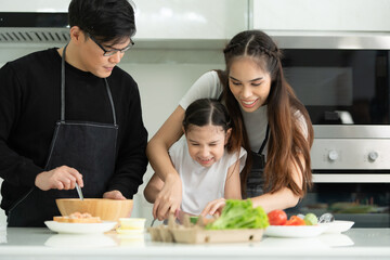 Asian family They are having cooking together happily in the kitchen room of the house.